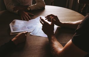 Three people sitting at a desk having a discussion